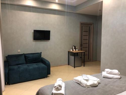 a living room with a blue couch and a tv at Tbilisi Sea Hotel in Tbilisi City