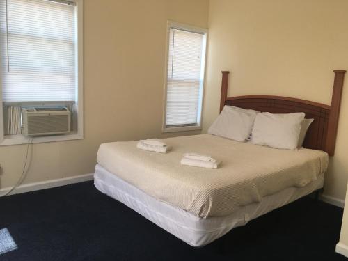 ベルマーにあるThe Belmar Innのベッドとタオル2枚のある寝室