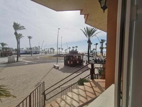 widok na ulicę z palmami i wózkiem w obiekcie Apartamentos Sanlúcar Beach 2 y 3 w mieście Sanlúcar de Barrameda