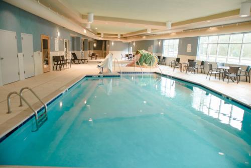 a swimming pool with a woman in a wedding dress in a hotel at Holiday Inn Express Winona by IHG in Winona