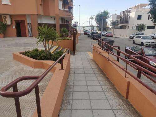 a sidewalk next to a street with parked cars at Apartamentos Sanlúcar Beach 2 y 3 in Sanlúcar de Barrameda