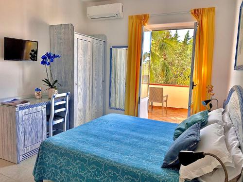 Resort Villa Flavio في ايسكيا: غرفة نوم بسرير ومكتب ونافذة