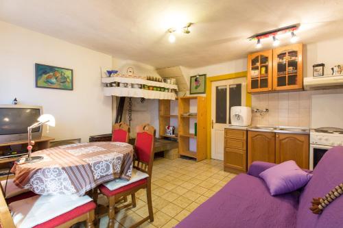 a kitchen and living room with a table and a couch at Crni in Drenje
