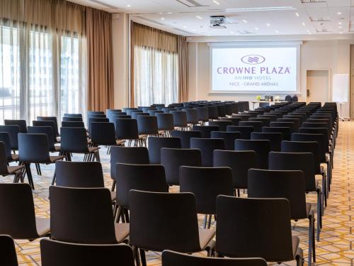 a room filled with chairs and a projection screen at Crowne Plaza - Nice - Grand Arenas by IHG in Nice