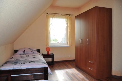 ein Schlafzimmer mit einem Bett, einer Kommode und einem Fenster in der Unterkunft verano in Osieki