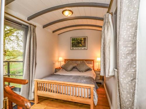 Schlafzimmer mit einem Bett und einem Fenster in der Unterkunft The Carriage at High Barn Heritage in Halstead