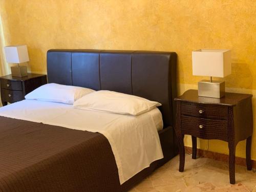 a bedroom with a bed and a nightstand with two lamps at Casa Casteldaccia 2 in Casteldaccia