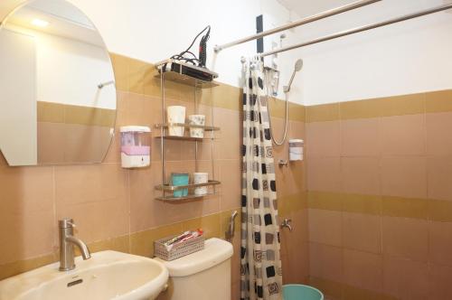 a bathroom with a sink and a toilet and a mirror at Mint Homes in CEV Mansion in Manila