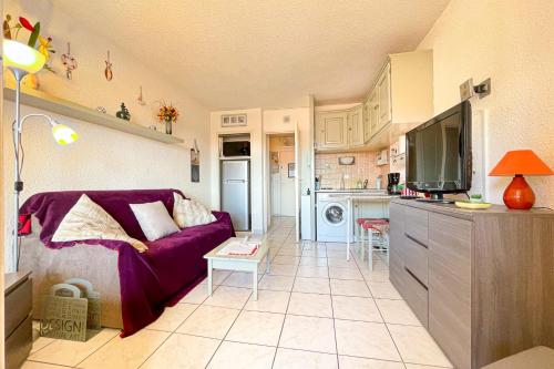 Il comprend un salon avec un canapé violet et une cuisine. dans l'établissement Bright apartment with pool, à Fréjus