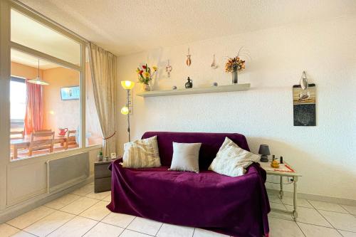 - un salon avec un canapé violet et des oreillers dans l'établissement Bright apartment with pool, à Fréjus