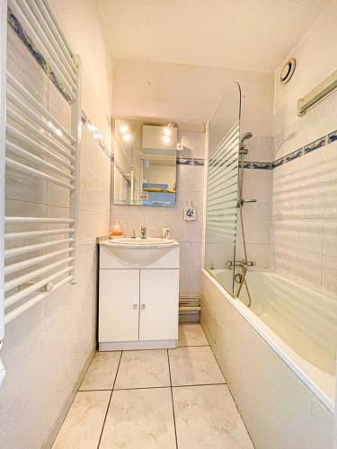 une salle de bain avec un lavabo, une douche et une baignoire dans l'établissement Bright apartment with pool, à Fréjus