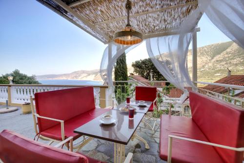 a table and chairs on a balcony with a view of the ocean at Villa IRENE in Zóla