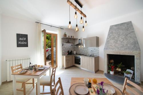 a kitchen and living room with a table and a fireplace at HedèraRooms in Agerola