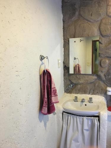 a bathroom with a sink and a towel at UTU TOCO - casa de piedra en lengua Huarpe in Potrerillos