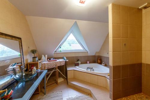 baño con lavabo, bañera y ventana en Chambre avec grand lit, en Soultz-sous-Forêts