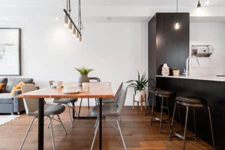 a kitchen with a table and chairs in a room at Sleek Condo in the Heart of Little Italy by Den Stays in Montréal