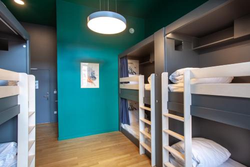 a room with bunk beds with a green wall at The People - Strasbourg in Strasbourg