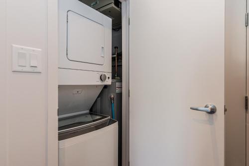 an open door to a kitchen with a microwave at Huge New Flat well Located closed on St-Denis Street by Den Stays in Montréal