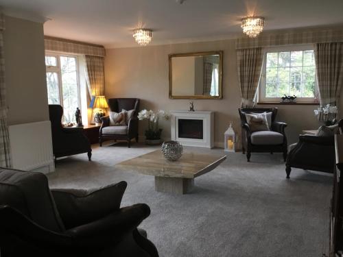 a living room filled with furniture and a table at Westlea Guest House in Alnmouth