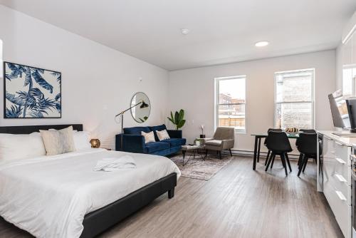 a bedroom with a bed and a living room with a table at Modern and New Studio in the Heart of the City by Den Stays in Montréal