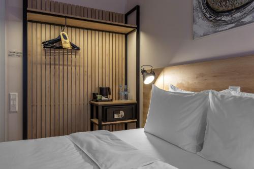 a bedroom with a white bed with a wooden headboard at KONTRAKT Boutique Hotel in Kyiv