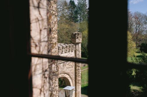 a window view of a stone building with a gate at Hotel Schloss Neetzow in Neetzow