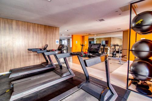 un gimnasio con cintas de correr y elípticas en una habitación en 360 Suítes Vibe República - Apartamentos mobiliados, en São Paulo