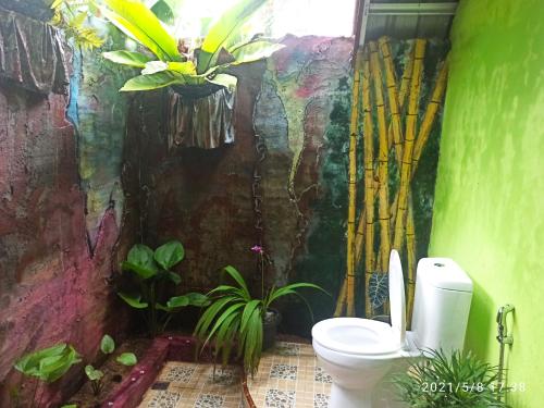 a bathroom with a toilet and plants in it at Green Forest Tangkahan in Tangkahan
