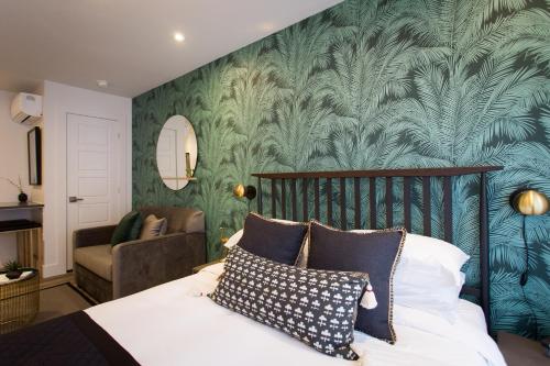 a bedroom with a bed and a green wall at Blue Tropics Studio in Little Italy with kitchen by Den Stays in Montréal