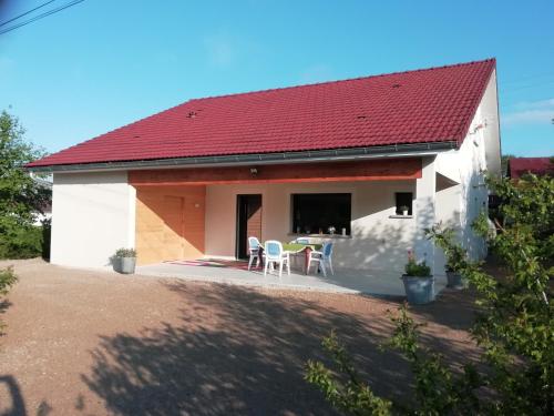 uma pequena casa branca com um telhado vermelho em Gite les carriaux em Le Fied