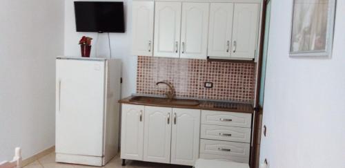 a kitchen with a sink and a white refrigerator at Villa Shpetim Zogaj. in Ksamil