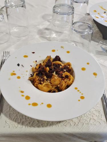 a white plate of food on a table at Sotto Il Cielo Hotel in Pignola