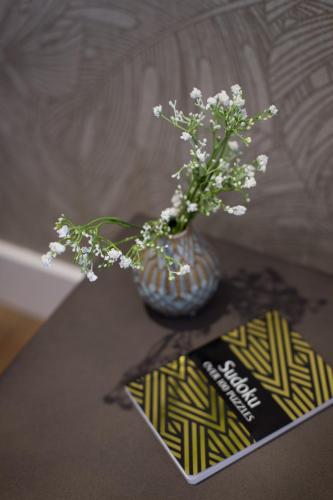 a vase with white flowers sitting on a table at Scandinavian Studio with Full Kitchen and Bath by Den Stays in Montréal
