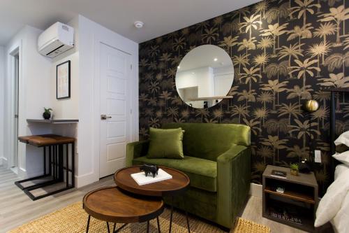 sala de estar con sofá verde y espejo en 16 Studio Apartment-Hotel in Little Italy by Den Stays, en Montreal