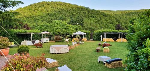 a garden with tables and chairs in the grass at Sotto Il Cielo Hotel in Pignola