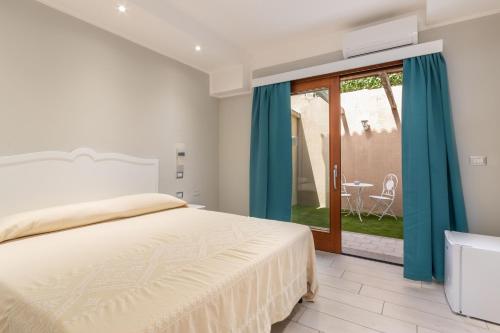 Domu Ajaju Guest House في فيلاسيميوس: غرفة نوم بسرير وباب زجاجي منزلق