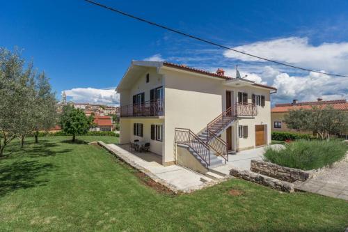 a white house with a staircase in a yard at Holiday Home with pool in Višnjan in Farini