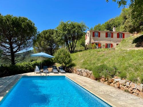 a swimming pool in front of a house at Holiday Home Villa St Arnoux in Seillans