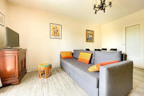 un salon avec un canapé gris et une télévision dans l'établissement Superb Apartment With Balcony In Frejus, à Fréjus