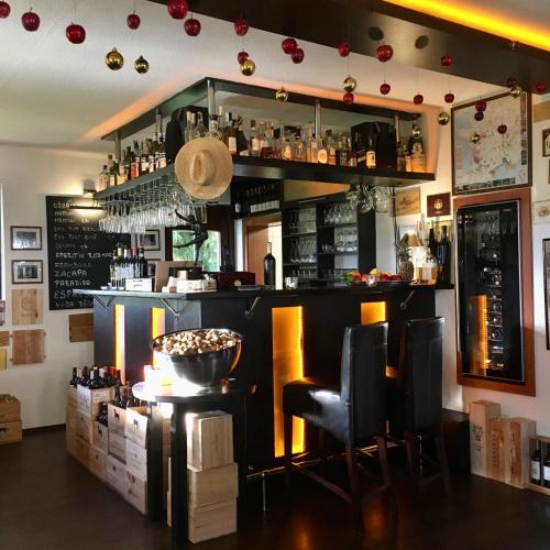 a bar in a restaurant with a counter and chairs at Villa Rozmaryn & Gourmet in Mariánské Lázně