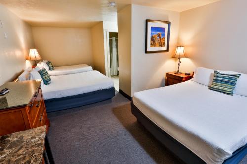 a hotel room with two beds and a desk at The Chalet in St. George