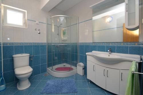 een blauw betegelde badkamer met een toilet en een wastafel bij Apartment in Karbuni with sea view, terrace, air conditioning, W-LAN 3609-1 in Blato