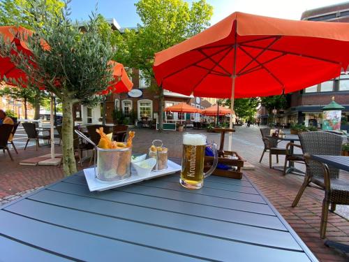 a table with a plate of food and a glass of beer at MediTerra in Papenburg