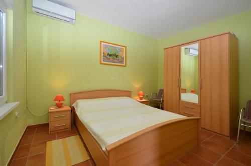 Dormitorio pequeño con cama y espejo en Apartment in Karbuni with sea view, terrace, air conditioning, W-LAN 3609-3, en Blato