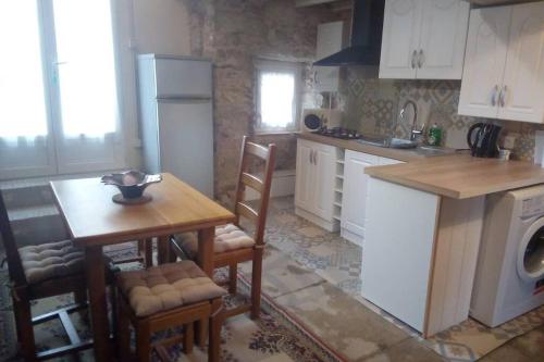 - une cuisine avec une table, une table et une cuisinière dans l'établissement Idéal pour les amoureux de la pierre intérieure, à Palluau