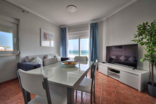 a living room with a dining table and a television at Apartamentos Belo Horizonte in Portimão