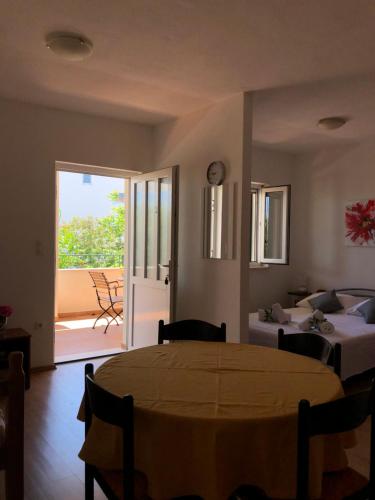 Habitación con mesa, cama y balcón. en Apartments Mira, en Trogir