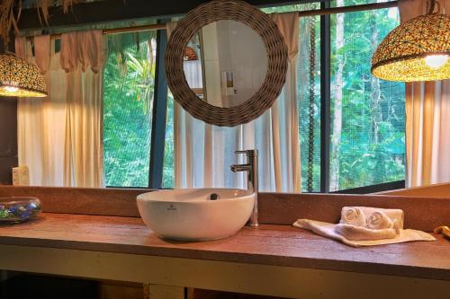 a bathroom counter with a sink and a mirror at Almonds and Corals Lodge in Puerto Viejo