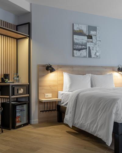 a bedroom with a large white bed and a table at KONTRAKT Boutique Hotel in Kyiv