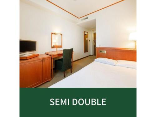 a bedroom with a bed and a desk with a computer at Plaza Hotel Premier - Vacation STAY 40087v in Fukuoka